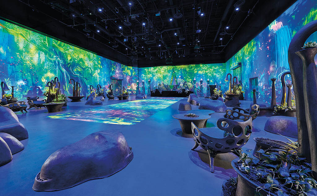 An immersive digital art installation transforming a large room with vibrant projections of a glowing forest.