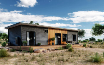Contemporary modular home with a dark facade and wooden entrance in a rural setting.