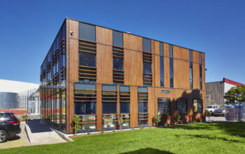 A contemporary office or commercial building with a mix of wood paneling and dark-framed windows.