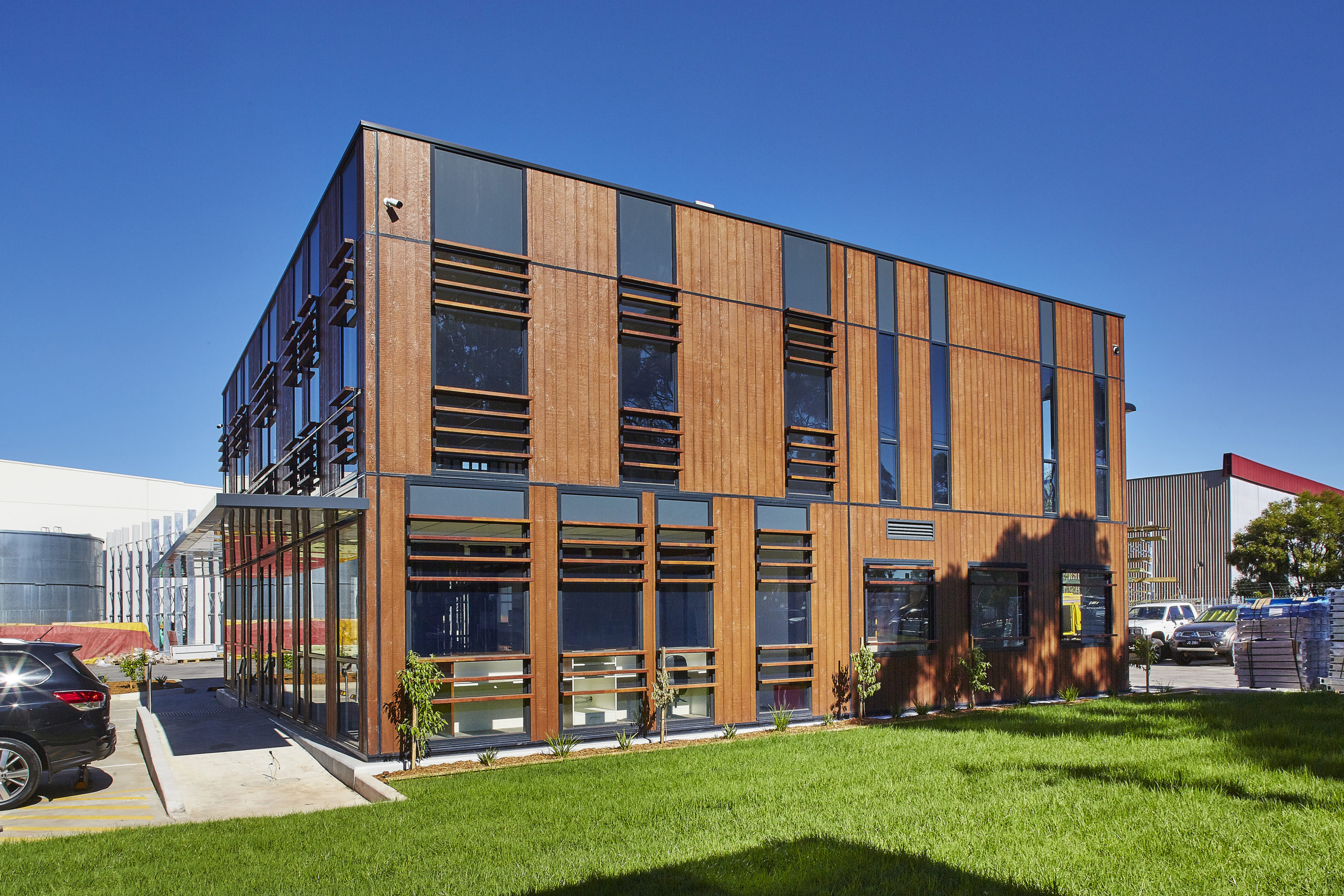 A contemporary office or commercial building with a mix of wood paneling and dark-framed windows.