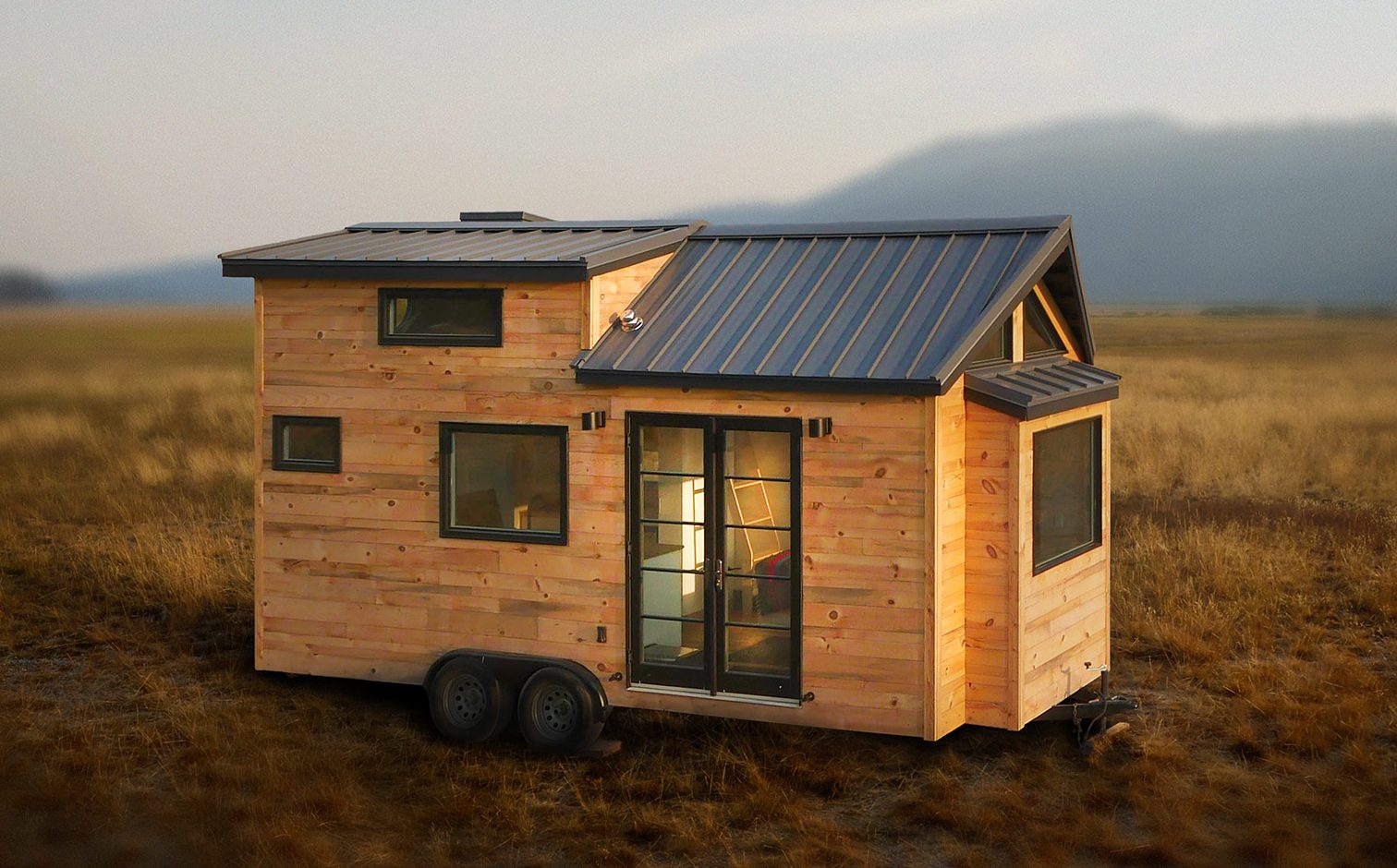 A portable tiny house with a rustic wooden exterior and a dark metal roof.